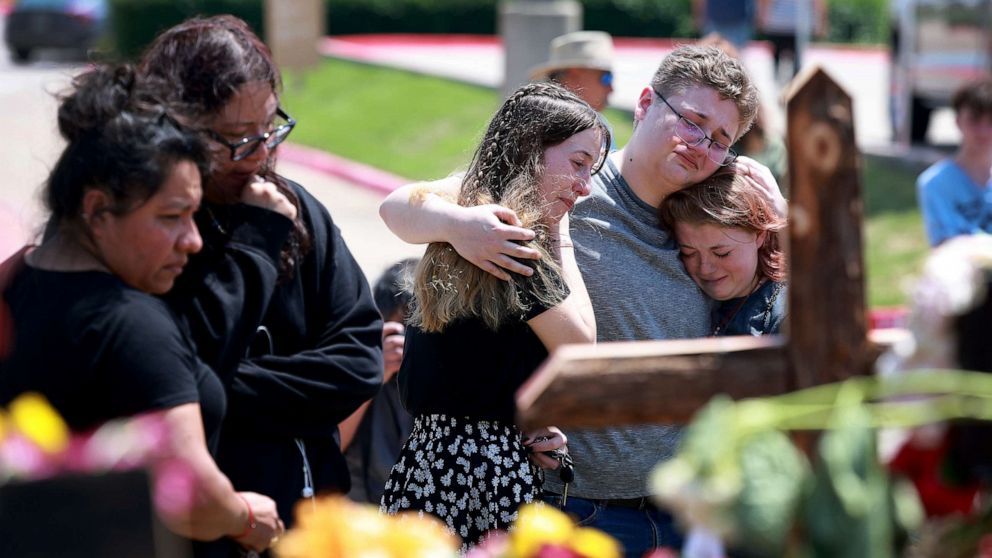 Jenni Seeley, Dakota Britvich, and Abbi Boyd hug as they visit a memorial set up near the scene of a mass shooting at the Allen Premium Outlets mall on May 8, 2023 in Allen, Texas. Jenni Seeley, Dakota Britvich, and Abbi Boyd hug as they visit a memorial set up near the scene of a mass shooting at the Allen Premium Outlets mall on May 8, 2023 in Allen, Texas.