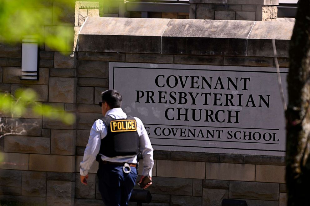 A police officer walks by an entrance to The Covenant School after a shooting in Nashville, Tenn., March 27, 2023.