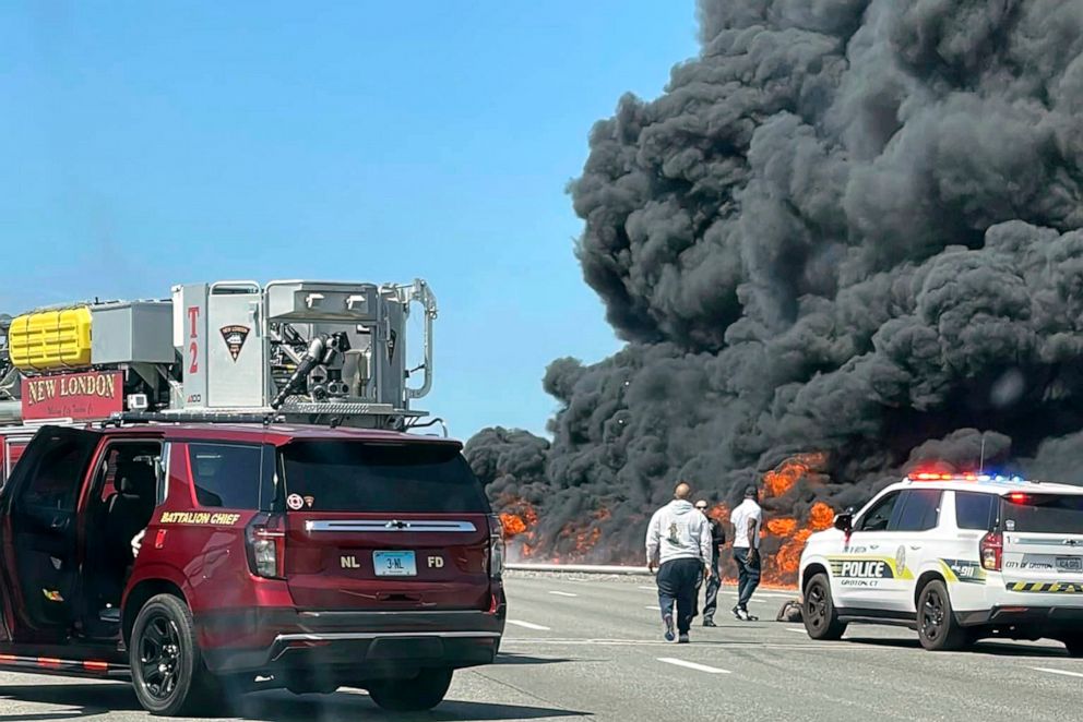 This photo provided by Angelique Feliciano shows firefighters and police responding after a crash involving a fuel truck and a car sparked a fire on the Gold Star Bridge between New London and Groton, Conn., on April 21, 2023.