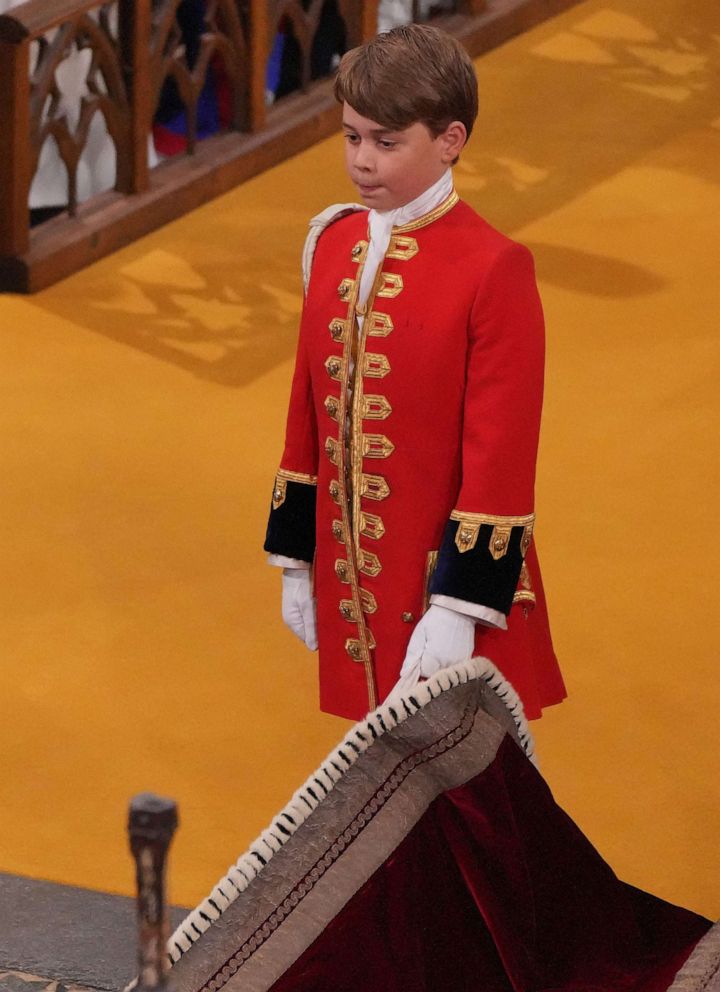 Britain's Prince George of Wales holds the robe of Britain's King Charles III at Westminster Abbey, in central London on May 6, 2023, during the Coronation.